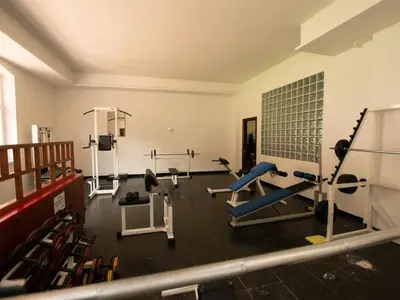 a gym with several treadmills and machines in a room at Villaggio Turistico Ploner in Carbonin
