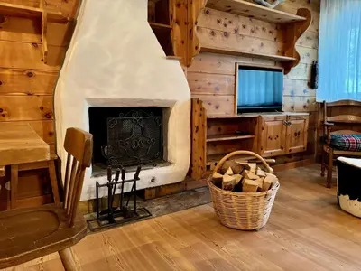 a living room with a fireplace and a television at Spacious Alpine Retreat & Parking in Cortina dʼAmpezzo