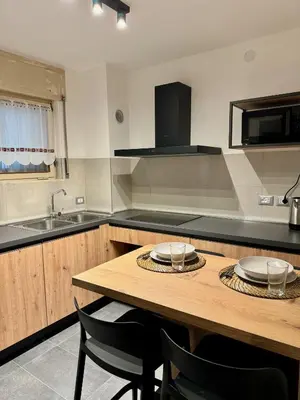 a kitchen with a wooden table with plates on it at Spacious Alpine Retreat & Parking in Cortina dʼAmpezzo