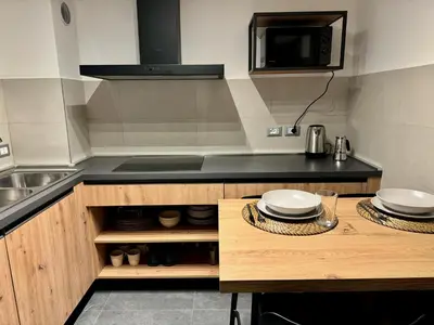 a kitchen with a sink and a counter with plates on it at Spacious Alpine Retreat & Parking in Cortina dʼAmpezzo
