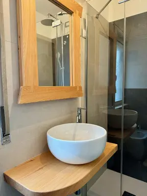 a bathroom with a white sink and a mirror at Spacious Alpine Retreat & Parking in Cortina dʼAmpezzo