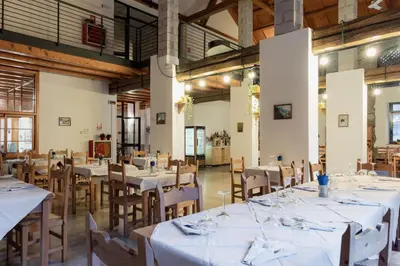 a dining room with white tables and wooden chairs at Ostello IMPERINA in Zenich