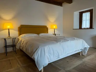 a bedroom with a bed with two lamps on two tables at Alte Stube - Antica dimora nelle Dolomiti in Transacqua
