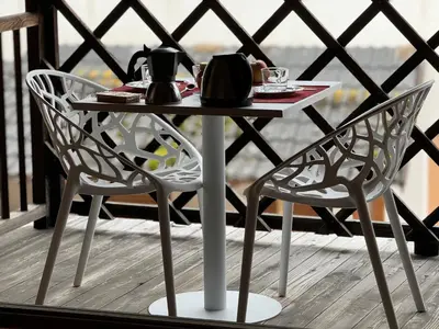a table and two chairs on a balcony at Alte Stube - Antica dimora nelle Dolomiti in Transacqua