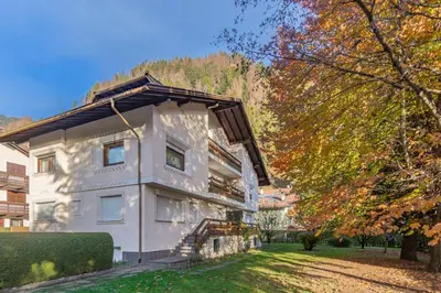 a white house with a gambrel roof at CASA PINUCCIA APPARTAMENTO OVEST in Predazzo