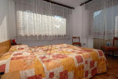 a bedroom with a bed with a quilt on it at CASA PINUCCIA APPARTAMENTO OVEST in Predazzo