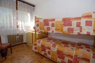 a bedroom with a bed with a quilt on it at CASA PINUCCIA APPARTAMENTO OVEST in Predazzo