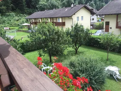 a view from the balcony of a house with flowers at CASA PINUCCIA APPARTAMENTO OVEST in Predazzo