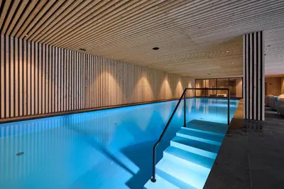 a swimming pool with stairs in a building at Wellness-Sporthotel Ratschings in Racines