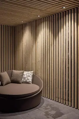 a circular couch in a room with a wooden wall at Wellness-Sporthotel Ratschings in Racines