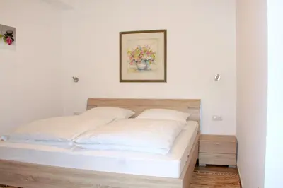 a bed in a bedroom with a picture on the wall at Haus Zöschg in Andrian