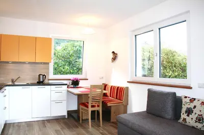 a kitchen and living room with a table and a couch at Haus Zöschg in Andrian