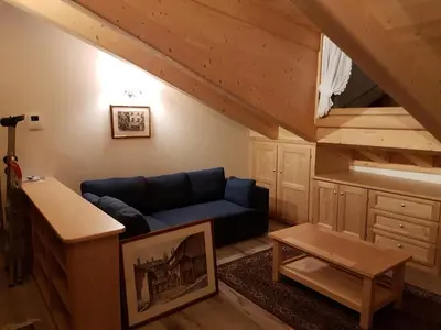 a living room with a blue couch in a attic at Casa De Sandre in San Vito di Cadore