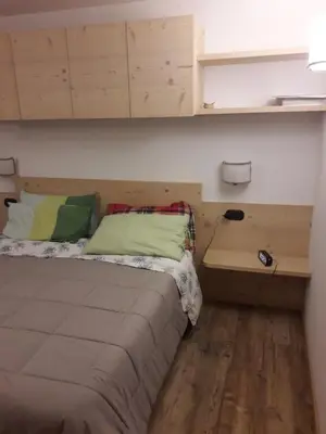 a small bedroom with a bed and a desk at Casa De Sandre in San Vito di Cadore