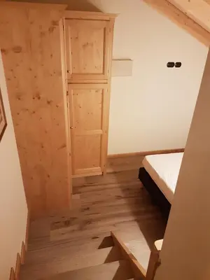 a small room with a bed and a door at Casa De Sandre in San Vito di Cadore