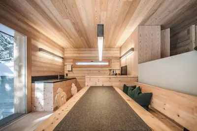 a sauna with wooden walls and ceilings and green pillows at Mountain Lodge Tamersc in San Vigilio Di Marebbe