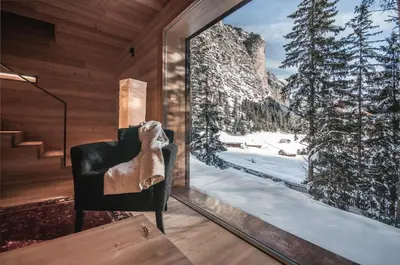 a room with a window with a picture of a snowy mountain at Mountain Lodge Tamersc in San Vigilio Di Marebbe