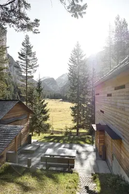 a patio with two benches next to a building at Mountain Lodge Tamersc in San Vigilio Di Marebbe