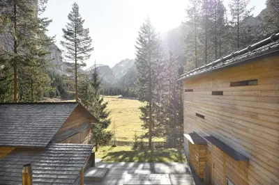 a house with a view of a field between two buildings at Mountain Lodge Tamersc in San Vigilio Di Marebbe