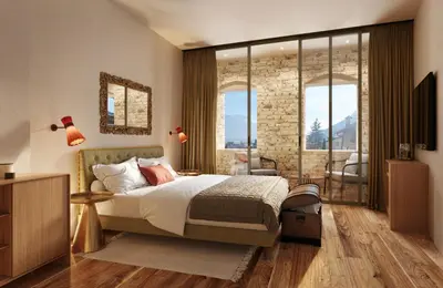 a bedroom with a king sized bed and large windows at Langenmantel Historic Suites in Termeno