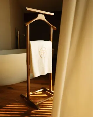 a towel hanging on a towel rack next to a curtain at Langenmantel Historic Suites in Termeno