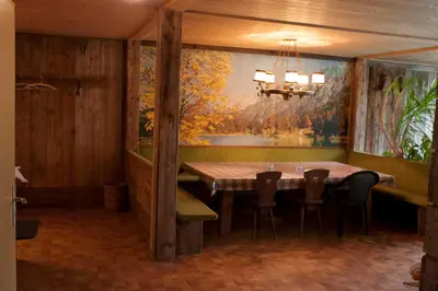 a dining room with a table and chairs and a painting at Ferienwohnungen Schnarf in Valdaora