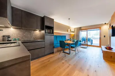 a kitchen with a table and a dining room at Rienz Alpine City Suites in Brunico