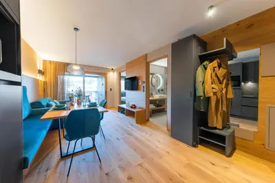 a kitchen and living room with a table and a dining room at Rienz Alpine City Suites in Brunico