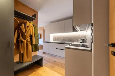 a kitchen with a coat hanging on a shelf at Rienz Alpine City Suites in Brunico