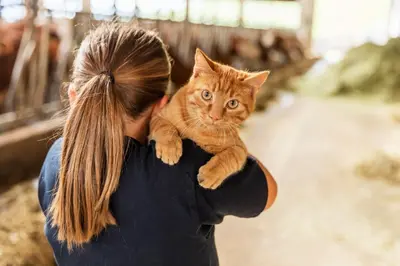a woman holding a cat on her shoulder at Formsunhof in Siusi