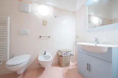a white bathroom with a toilet and a sink at Casa dei Caprioli in Pera