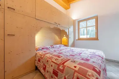a bedroom with a bed in a wooden wall at Casa dei Caprioli in Pera