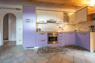 a kitchen with purple cabinets and a tile floor at Casa dei Caprioli in Pera