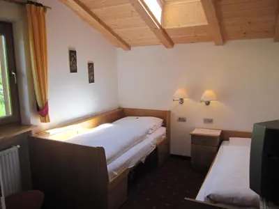 a room with two beds and a tv in it at Garni Sonneck in Laion