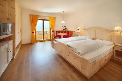 a bedroom with a large bed and a television at Garni Sonneck in Laion
