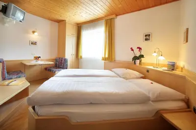 a bedroom with a large white bed with a window at Garni Sonneck in Laion