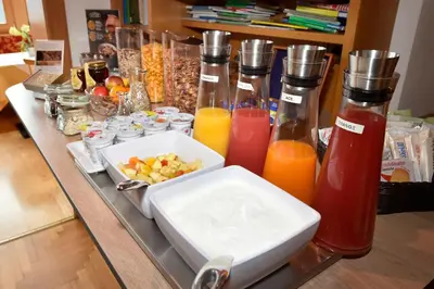 a table with bottles of juice and a bowl of fruit at Garni Sonneck in Laion