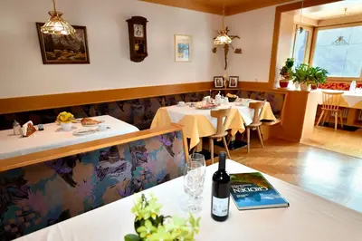 a dining room with tables and chairs in a restaurant at Garni Sonneck in Laion