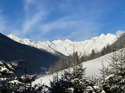 a snow covered mountain range with a christmas tree at Apartment Weisswand in Colle Isarco