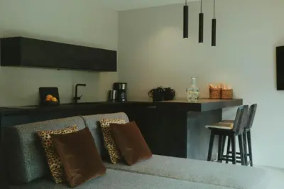 a living room with a couch and a kitchen at Solterra Poolhouse 2 in Tisens