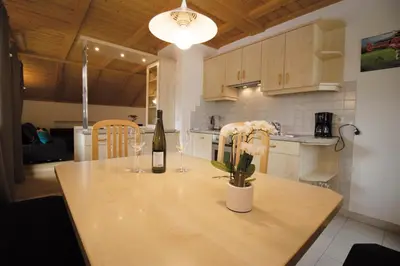 a kitchen with a table with a bottle of wine and flowers at Apartment Obkircher in Nova Levante