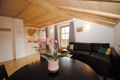 a living room with a couch and a table with flowers on it at Apartment Obkircher in Nova Levante