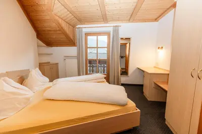 a bedroom with two beds and a desk and a window at Apartment Obkircher in Nova Levante