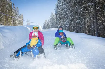 two adults and two children playing in the snow at Apartment Obkircher in Nova Levante