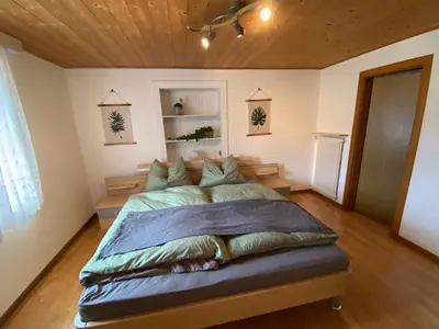 a bedroom with a large bed with a wooden ceiling at Apartment Kesselkogel - Rosenheim Apartments in Tires