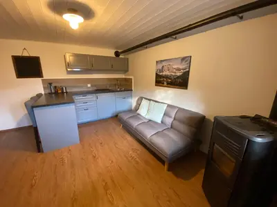 a living room with a couch and a kitchen at Apartment Kesselkogel - Rosenheim Apartments in Tires