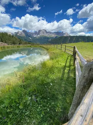 a fence next to a river with mountains in the background at Apartment Kesselkogel - Rosenheim Apartments in Tires
