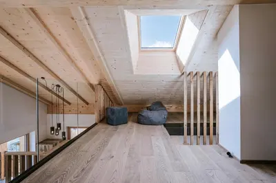 an attic room with a skylight and a couch at Chalets Hansleitner in Terento