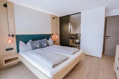 a bedroom with a large bed in a room at Chalets Hansleitner in Terento