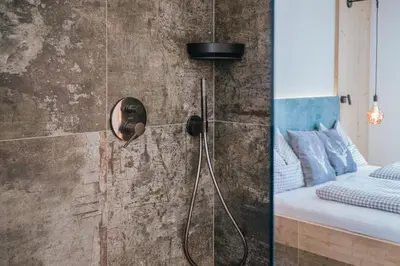 a shower in a bedroom with a bed at Chalets Hansleitner in Terento
